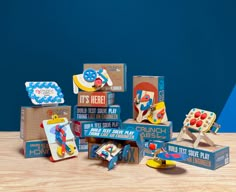 an assortment of wooden toys sitting on top of a wood table in front of a blue wall