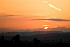 the sun is setting behind some mountains