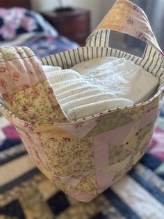 an empty basket sitting on top of a quilted table cloth covered bed spreader