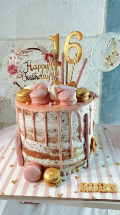 a birthday cake with pink frosting and gold decorations