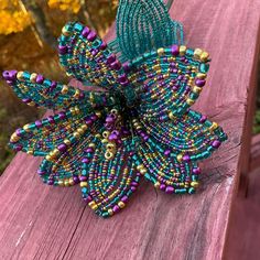 a beaded brooch sitting on top of a wooden table