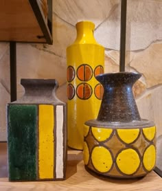 three vases sitting on top of a wooden table