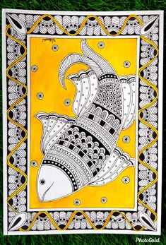 a yellow and white painting on grass with an intricate design in the middle, depicting two fish