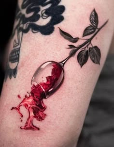 a red liquid pouring out of a magnifying glass onto the arm of a woman