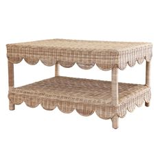 a wicker coffee table with scalloped edges and a shelf on the top