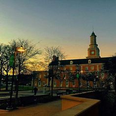 an old building with a clock tower at sunset