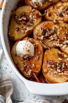 a white dish filled with sliced bananas and ice cream on top of a table cloth