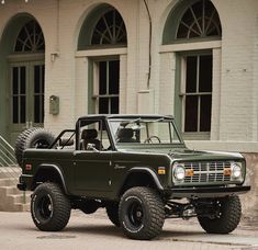 a green truck parked in front of a building