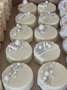 some cookies are decorated with pearls and white icing on top of each cookie sheet