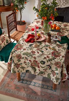 the table is set with flowers and fruit