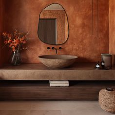 a bathroom with a sink, mirror and vase filled with flowers on the counter top