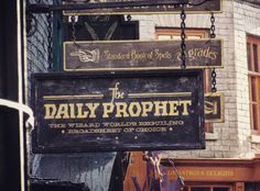 a sign hanging from the side of a building that says, the daily prophet