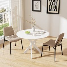 a white table with chairs around it in front of a window and pictures on the wall