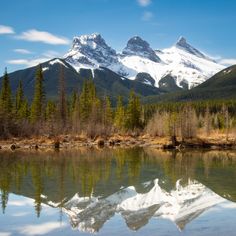 the mountains are reflected in the still water