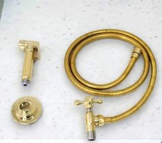 a gold colored shower hose and faucet on a white counter top