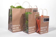 three grocery bags with vegetables in them sitting side by side on a white background the bag has reuse recycle written on it