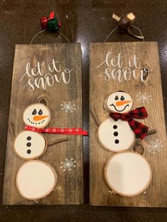 two wooden signs with snowmen painted on them