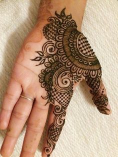 a woman's hand with henna tattoos on it