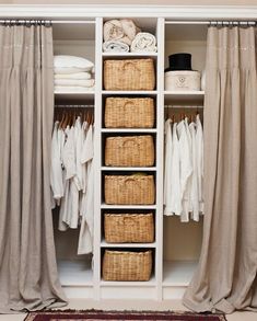 the closet is filled with clothes and wicker baskets on it's shelves, along with curtains