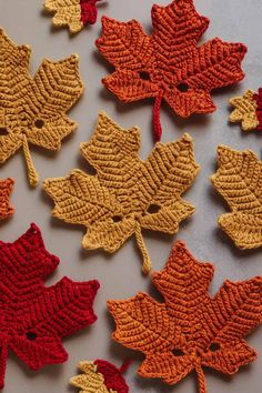 crocheted autumn leaves are arranged on a table