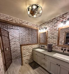 a bathroom with two sinks and brick walls