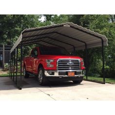 a red truck is parked in a carport