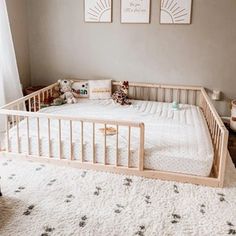 a baby crib in the corner of a room with two pictures on the wall