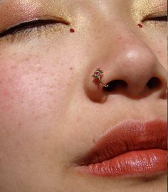 a close up of a woman's nose and nose piercing