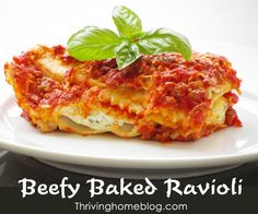 a white plate topped with lasagna covered in sauce and basil