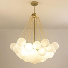 a chandelier hanging from the ceiling in a room with white walls and flooring