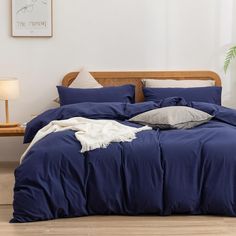 a bed with blue sheets and pillows in a room