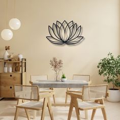 a dining room table with chairs and a large metal flower on the wall