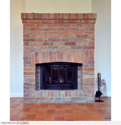 a brick fireplace in a living room with tile flooring