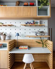 a desk with shelves and books on top of it in front of a white wall