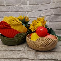 two knitted baskets with sunflowers and apples in them on a stone surface