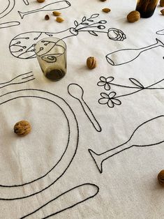 the tablecloth has drawings on it with nuts scattered around it, including a glass and spoon