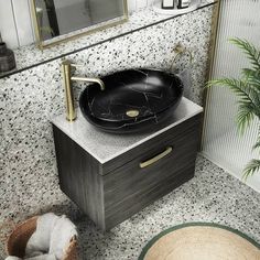 a black sink sitting on top of a counter next to a mirror