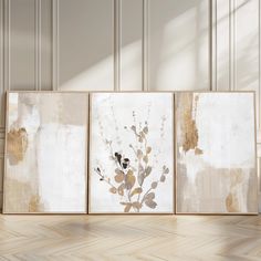 three framed art pieces on a wall in an empty room with parquet flooring