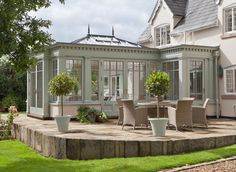 an orangery with chairs and tables in front of it