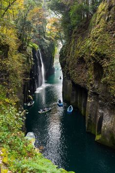 two boats are in the water near a waterfall