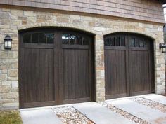 two brown garage doors in front of a brick building