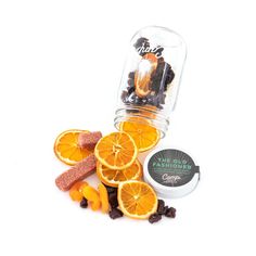 orange slices, raisins, and other fruit are arranged around a glass jar