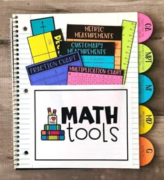 a notebook with some stickers on it next to pencils and markers that spell out math tools