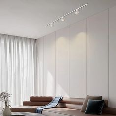 a living room filled with furniture next to a window covered in white curtains and drapes