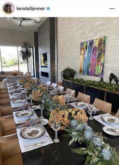 a long table with plates and flowers on it