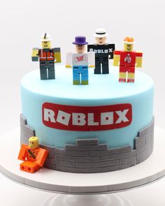 a cake with lego figures on it and the words roblox spelled in large letters