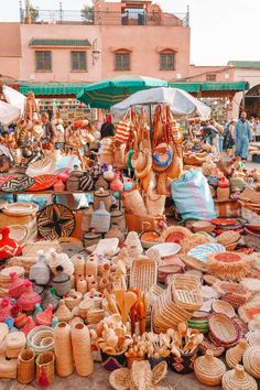 an outdoor market with baskets, baskets and umbrellas