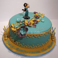 a cake decorated with flowers and a woman holding a wine glass in the air, on top of a table