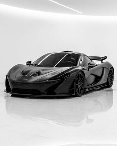 a black and white photo of a sports car in a room with no one around