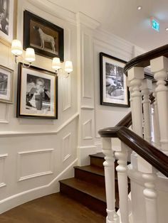 a staircase with pictures on the wall and wooden floors